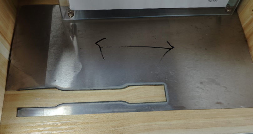 Machined flat stainless steel tensile test coupon removed from parent material